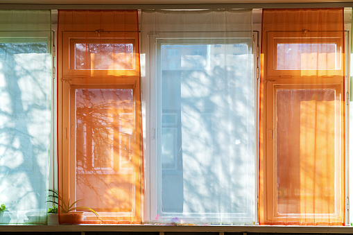 Window colorful blind is tightly closed in building room at sunny summer day