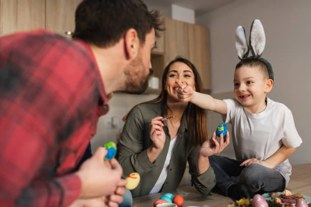 istock Cheerful family enjoying Easter day decorating Easter eggs 1387151147