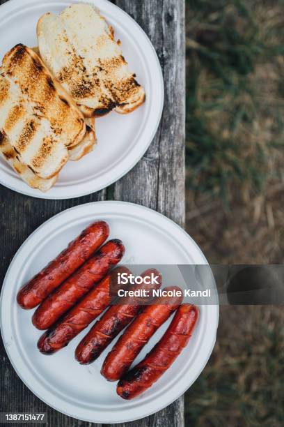Grilled Hotdogs And Buns On Paper Plates Stock Photo - Download Image Now - Hot Dog, Picnic Table, American Culture
