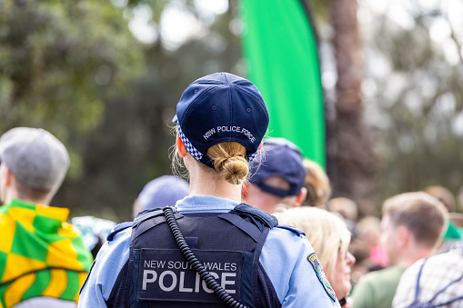 Sydney, Australia - March 20, 2022: George Street Sydney, young female police officer patrolling city streets
