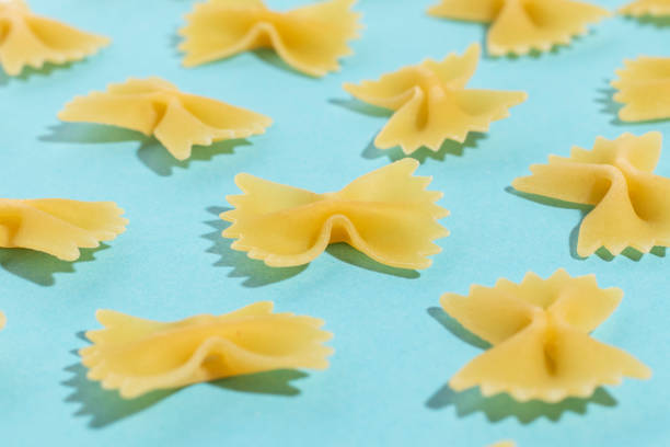 istock Uncooked italian farfalle pasta on a blue background. 1387152826