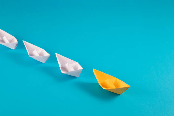 istock Yellow Paper Boat Leading Other Boats 1387155658