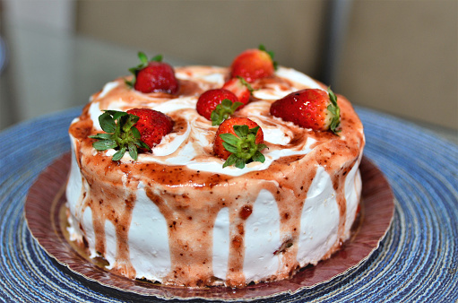 A nice and yummy whipped cream cake with jelly syrup and strawberries decorating