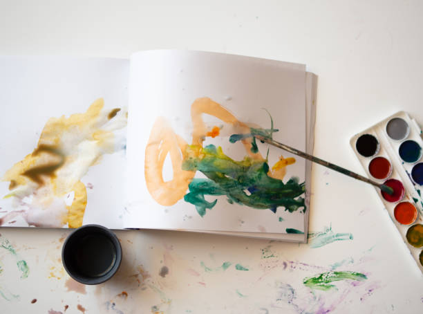 istock Children's drawing with watercolors in a sketchbook 1387156081