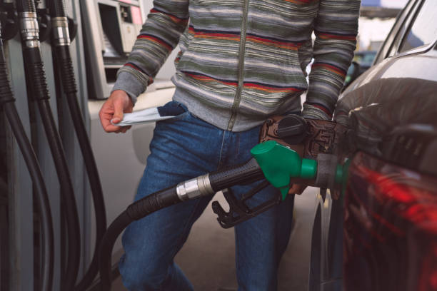 uomo con le tasche vuote a causa degli alti prezzi della benzina e del carburante. benzina costosa - pompa daria foto e immagini stock