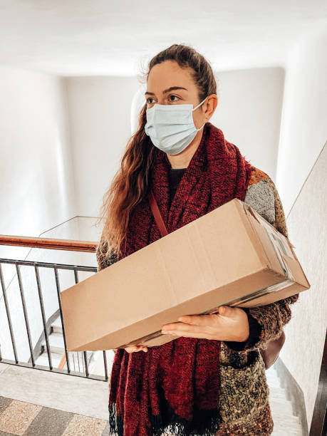 istock woman with box and face mask 1387161355