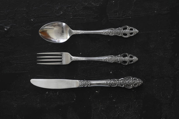 istock Overhead shot of silverware on black table with copy space. 1387168500