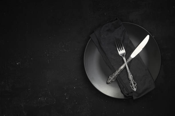 istock Empty black slate plate on dark stone table. Food background for menu, recipe. Table setting. Flatlay, top view. Mockup for restaurant dish 1387169333