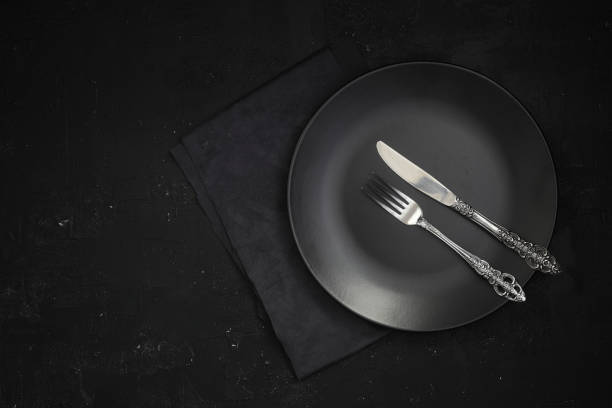istock Empty black slate plate on dark stone table. Food background for menu, recipe. Table setting. Flatlay, top view. Mockup for restaurant dish 1387169378