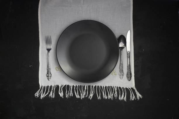 istock Empty black slate plate on dark stone table. Food background for menu, recipe. Table setting. Flatlay, top view. Mockup for restaurant dish 1387169483
