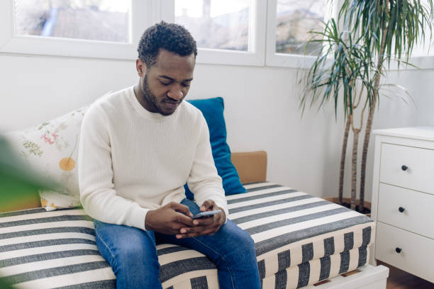 istock Happy African American man using a smartphone at home 1387172219