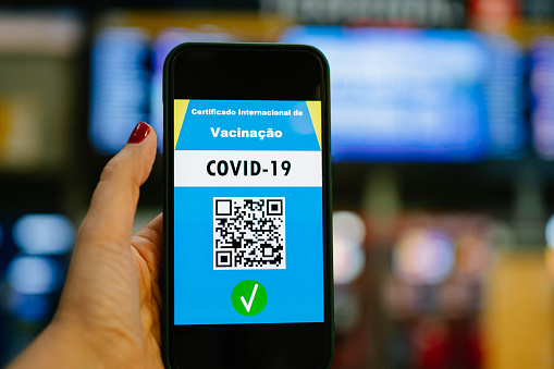 Woman's hand showing digital vaccine passport at airport