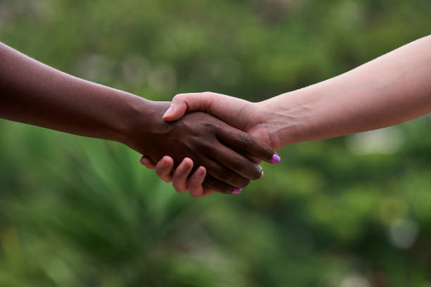 istock Handshake between black and white young woman. 1387176941