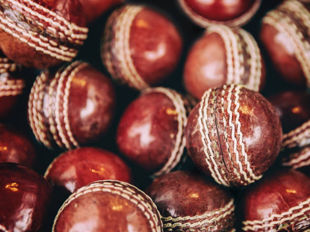 A background of vintage red leather cricket balls with white stitching. stock photo
