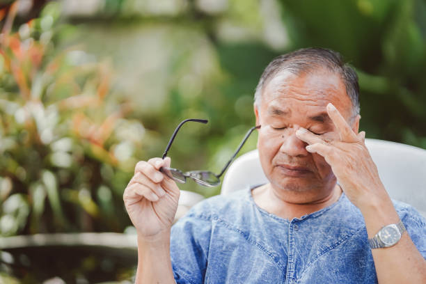 ein älterer mann, der sich aufgrund übermäßiger augenbeanspruchung die augen reibt und juckreiz und reizung verursacht. - human eye rubbing tired glasses stock-fotos und bilder