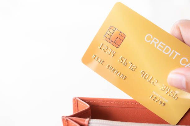 istock Finger holding credit card in wallet with white background 1387188366