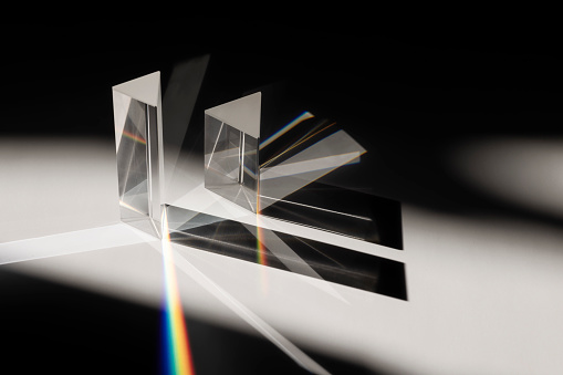 Multi triangular Prism dispersing sun beam splitting into a spectrum on white background
