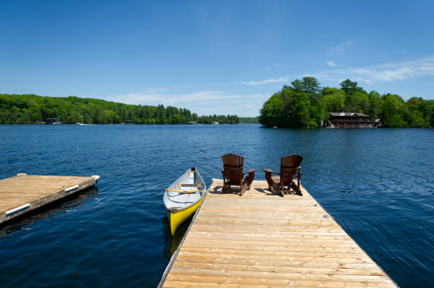 istock Yellow canoe and Adirondack chairs 1387191538