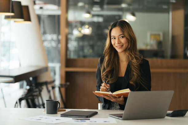 istock business asian woman hand taking notes with various items placed on the office table. online meeting, online learning concept 1387191885