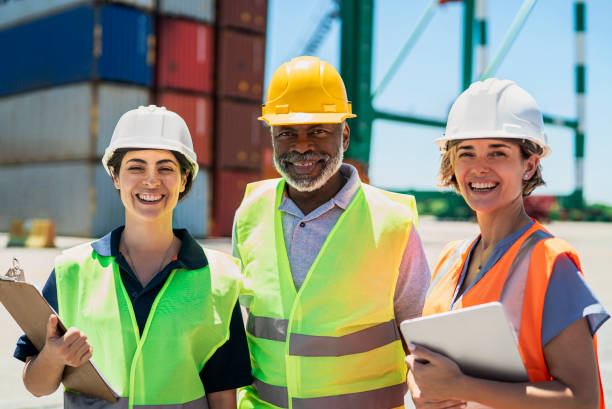 istock Foreman engineer and dock workers standing at shipping yard looking and smiling at the camera 1387192002