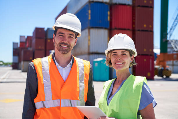 istock Dock control coworkers looking at the camera while standing at shipping yard 1387192034