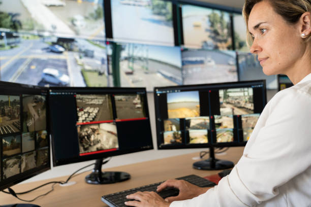 istock Adult female security worker watching monitors at control room 1387193240