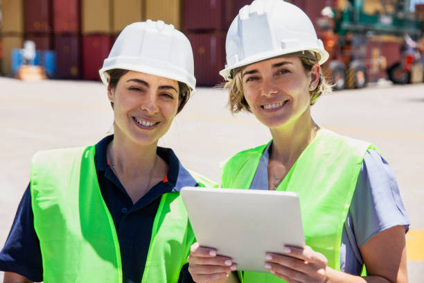 istock Female dock control coworkers smiling at the camera holding digital tablet 1387193280