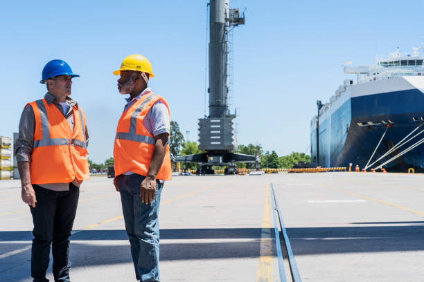 istock Male foreman engineer and dock worker having a meeting at shipping yard 1387193317