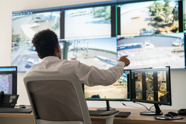 istock Young adult male security worker discussing while looking at video wall 1387193346