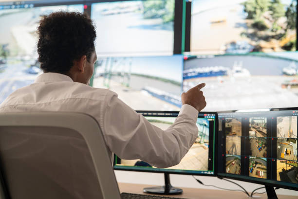 istock Young adult male security worker discussing while looking at video wall 1387193355