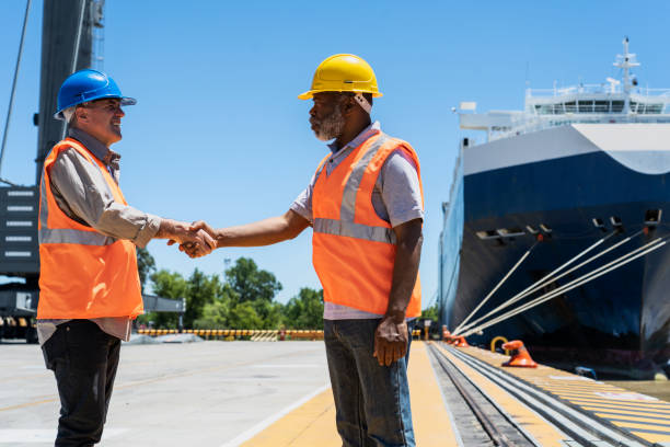 istock Male foreman engineer and dock worker shaking hands after discussing project 1387193418