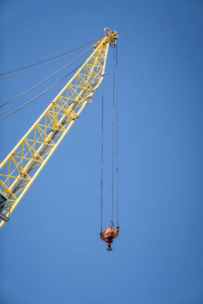 Low angle view of industrial crane against blue sky