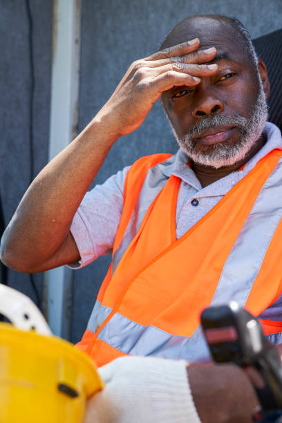 istock African american male cargo handler suffering a heat stroke while sitting in idustrial crane 1387194089