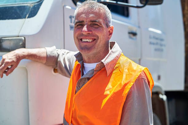 istock Male dock control worker smiling at the camera while leaning on truck 1387194149