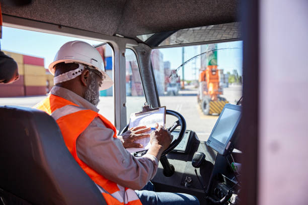 African american dock worker checking delivery information on clipboard while holding package