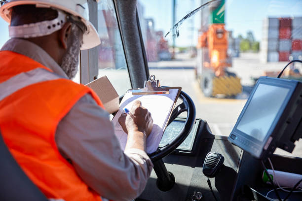 istock African american dock worker checking delivery information on clipboard while holding package 1387194312