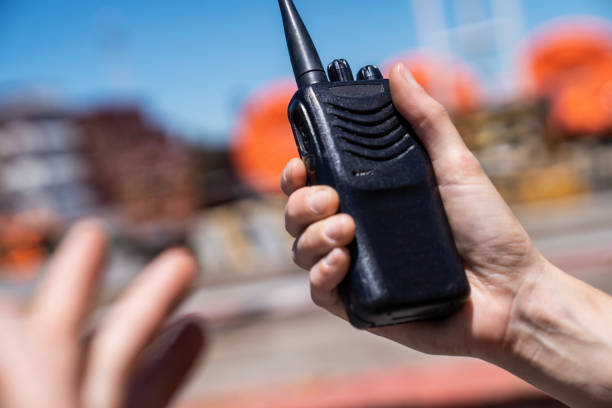 Midsection of man using walkie talkie during daytime