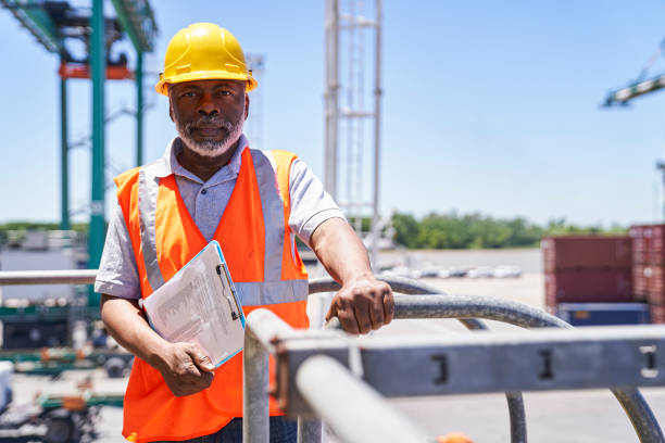 istock African american male cargo handler standing on harbor cargo crane while holding clipboard 1387194426