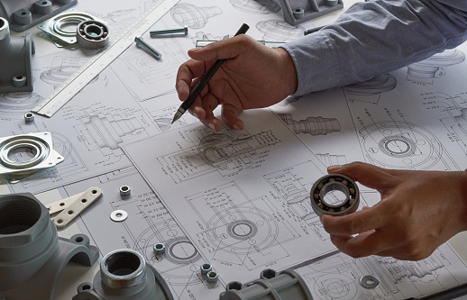 Engineer technician designing drawings mechanicalÂ parts engineering Engine
manufacturing factory Industry Industrial work project blueprints measuring bearings caliper tools
