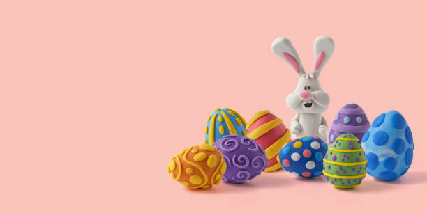 istock Easter greeting card with cute bunny and easter eggs. Handmade from plasticine on a pink background with copy space 1387200044