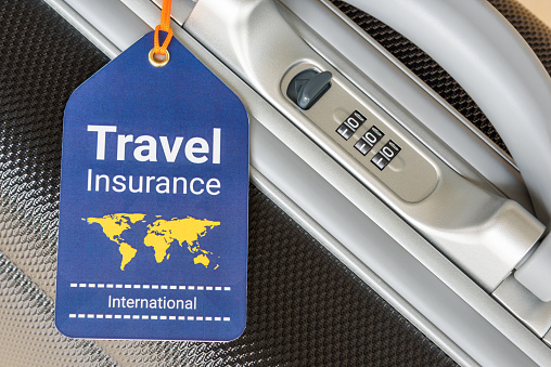 Travel safety and travel insurance concept : Travel insurance tag is hung near a numeric combination lock. Travel insurance is intended to cover lost luggage, trip cancellation, accident, losses, etc