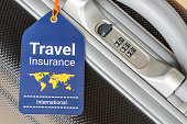 Travel safety and travel insurance concept : Travel insurance tag is hung near a numeric combination lock.