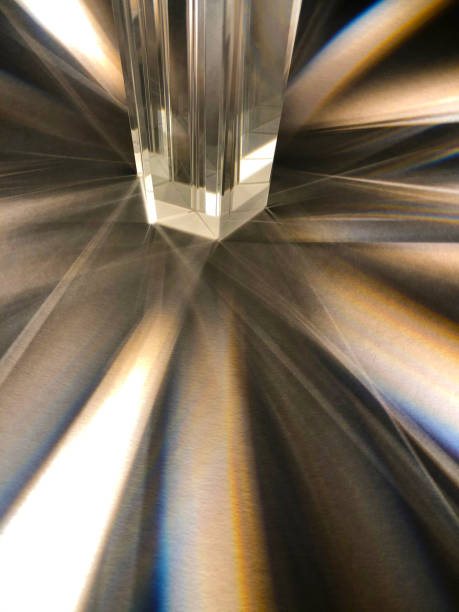 istock Close up of clear triangular glass prisms scattering beam of light with sparkling effect. 1387204465