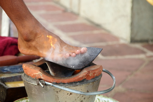 Iron plow plate is on clay fire pot and blur foot with above plow plate. Preparation equipment set for Thai massage in Northern style.