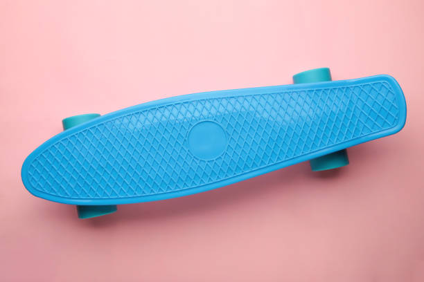istock Penny Skate board blue with blue wheels on pink background. 1387213840