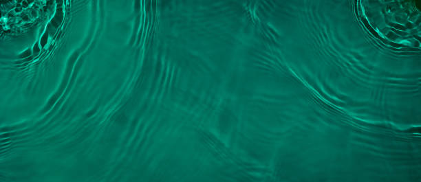 istock transparent dark green colored clear calm water surface texture 1387215730