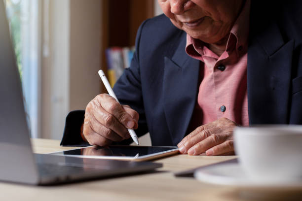 istock Business man hand using electronic pen writing on digital tablet 1387217487