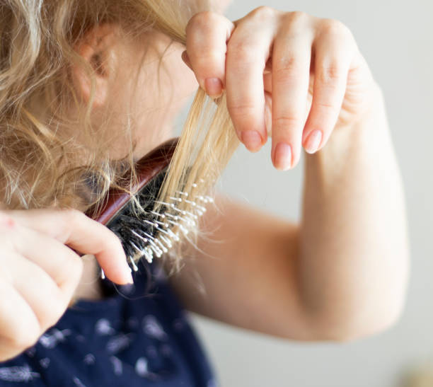 istock Combing with brush and pulls long hair. Daily preparation for looking nice. 1387219653
