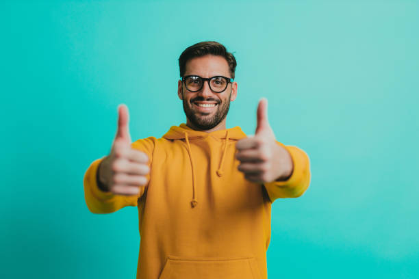 Young man wearing eyeglasses showing thumbs up