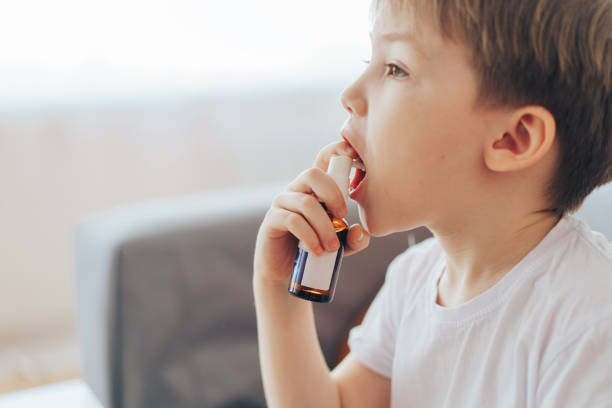 istock Boy splashing throat medicine close-up 1387221875